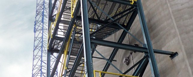 Steel framework of a large industrial structure with metal stairs and platforms, showcasing engineering precision.