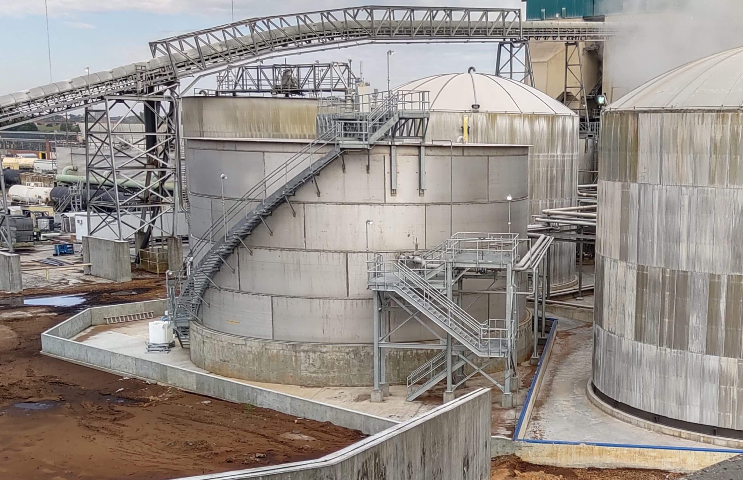 Industrial tank vessels with staircases and platforms, part of a large-scale facility, showcasing Larson Engineering's expertise in industrial design.