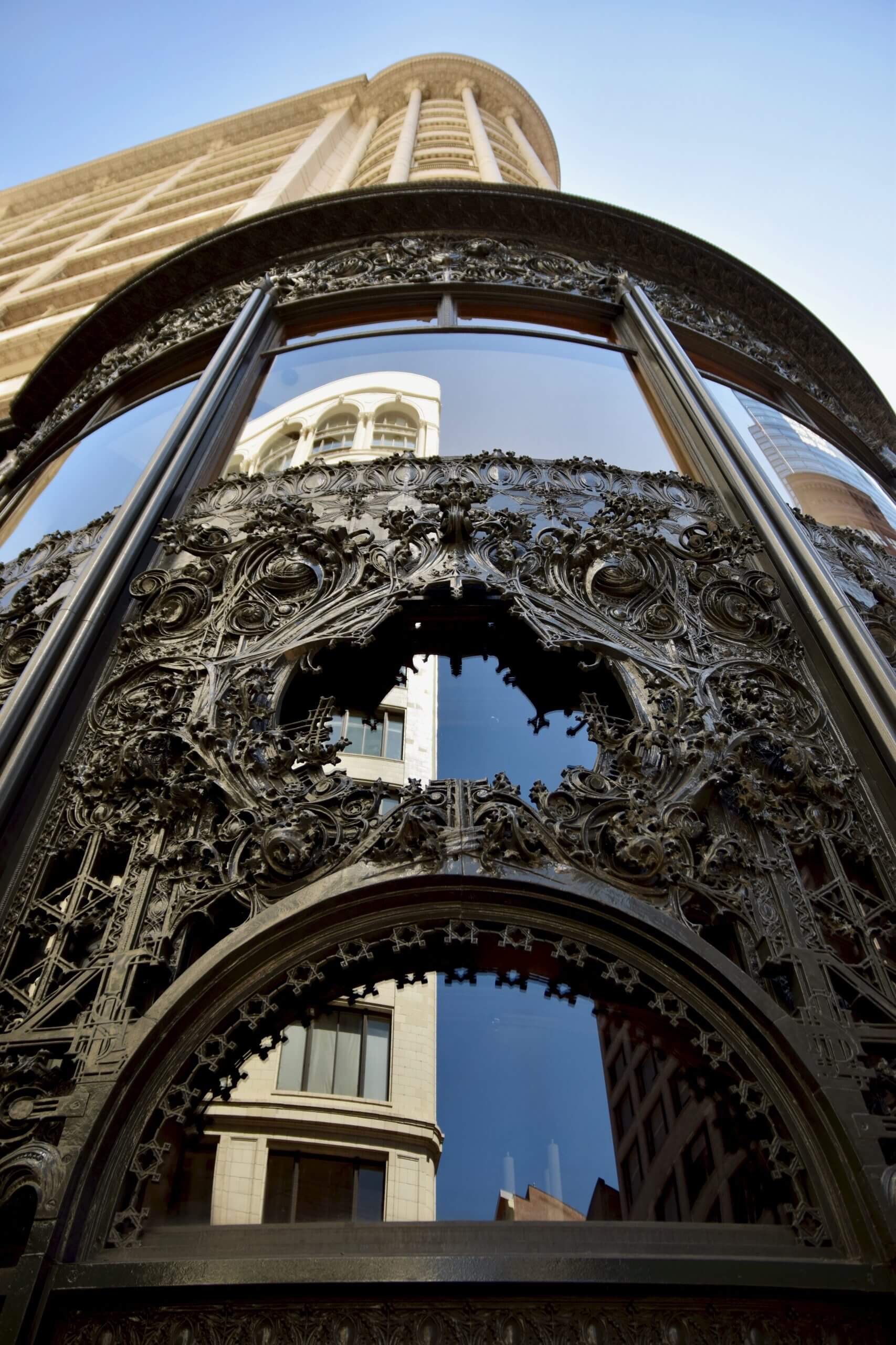 Ornate cast iron panels and glass storefront of the Sullivan Center, showcasing intricate detailing against a backdrop of historic architecture.